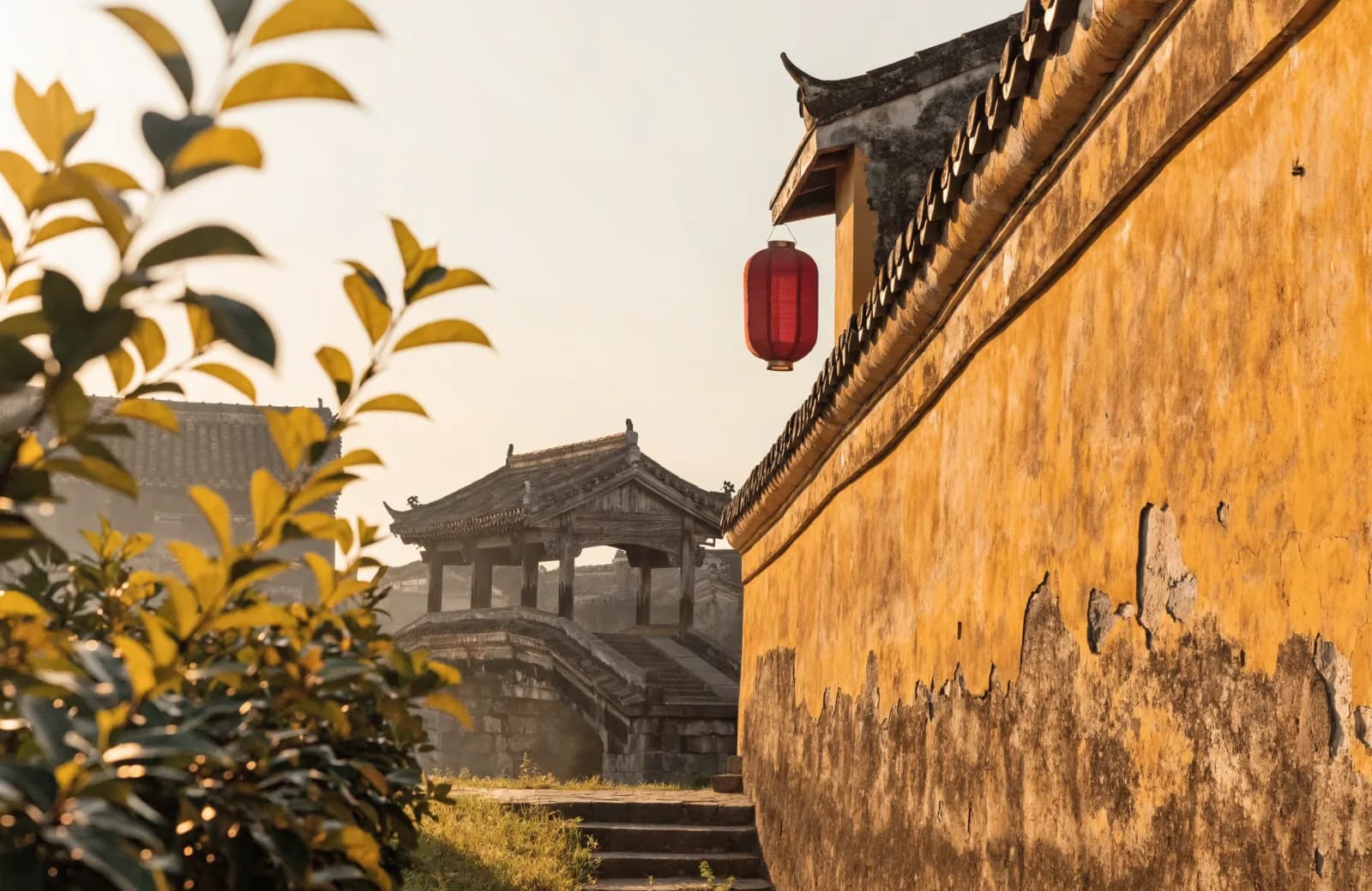 Hoi An Old Town's Japanese covered bridge in warm golden light with a red silk lantern